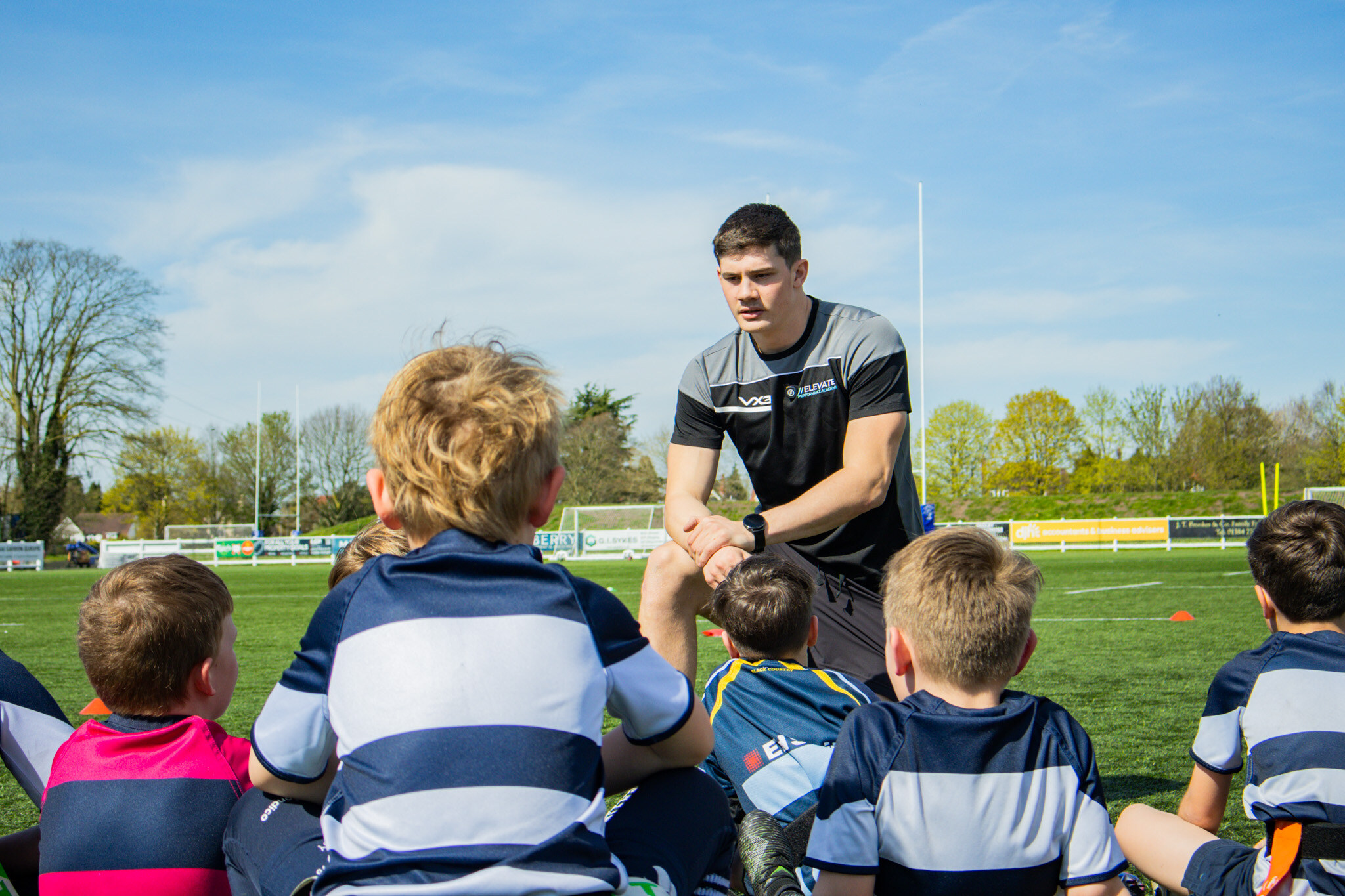 An Elevate coach supporting young people during a field activity