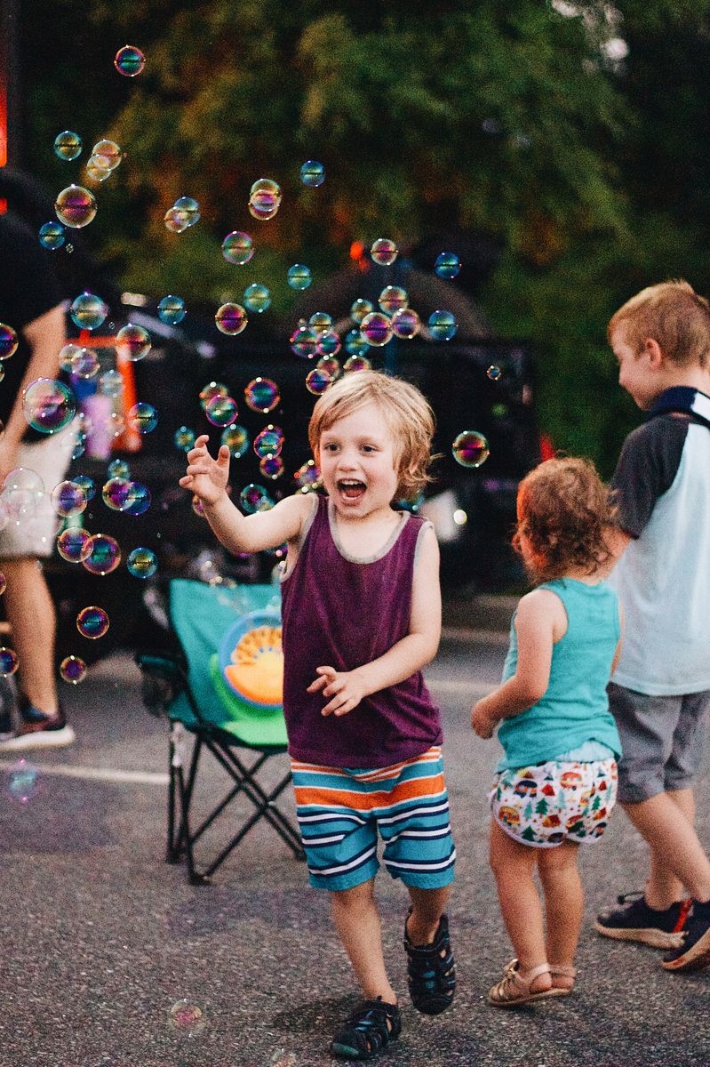 Children playing with bubbles at an outdoor family event